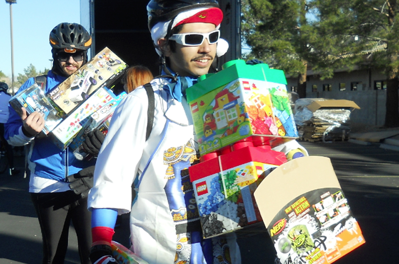 Braulio López Santamaría sobre la bici se apresta a regalar juguetes