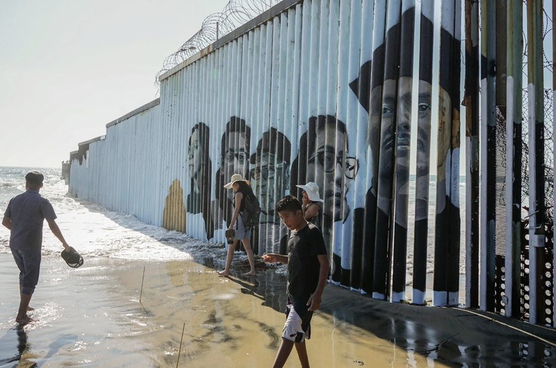Los rostros de deportados se plasman en el muro entre México y EE.UU.